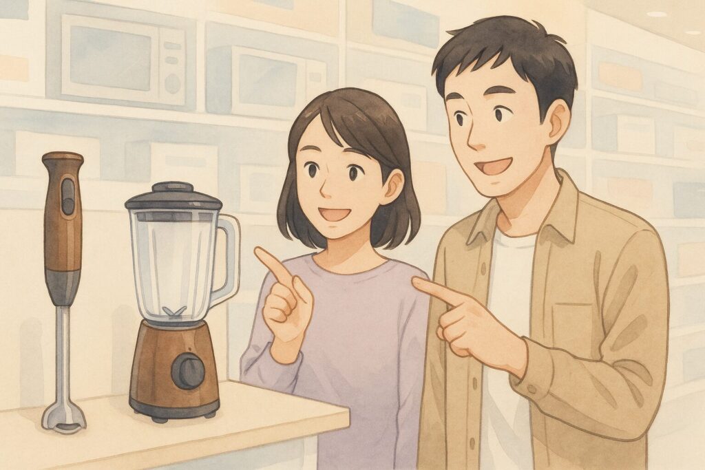 家電量販店で、日本人カップルがハンドブレンダーと据え置き型ブレンダーを比較しながら、楽しそうに話し合って選んでいる様子。